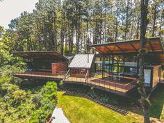 the house is surrounded by trees and has two decks that are connected to each other