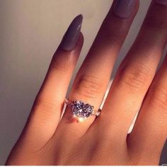 a woman's hand with a ring on it and a diamond in the middle