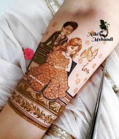 a woman with henna tattoos on her arm and leg, holding a man's hand