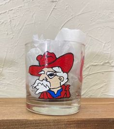 a glass with a cartoon character painted on it