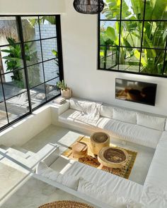 a living room with white furniture and large windows