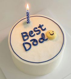 a birthday cake with the words best dad written on it and a smiley face candle