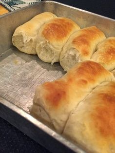 bread rolls sitting in a metal pan on top of a counter