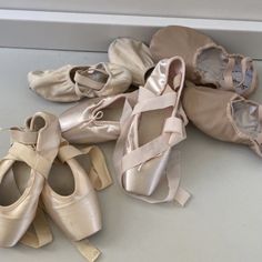 several pairs of ballet shoes are lined up on the floor