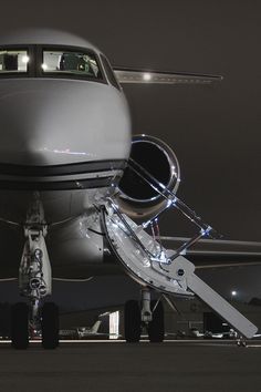 an airplane is parked on the runway at night with its door open and lights on