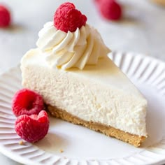 a slice of cheesecake with whipped cream and raspberries on a paper plate