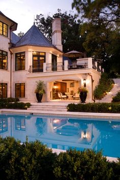 a large house with a pool in the front yard and stairs leading up to it