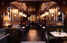 the interior of a restaurant with tables, chairs and chandeliers hanging from the ceiling