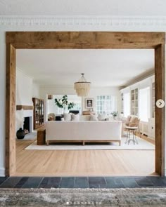 an open living room with white furniture and wood floors