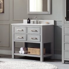 a bathroom vanity with a mirror, sink and towels on the shelf next to it