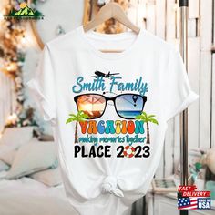 a white t - shirt with the words smith family vacation and sunglasses on it in front of a bed