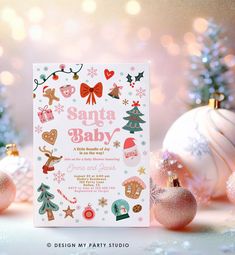 a baby's first christmas party card with ornaments and baubles on the table