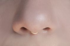 a close up view of a nose with a gold nose ring