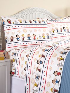 the bed is made with peanuts and charlie brown's characters on it, along with two pillow cases