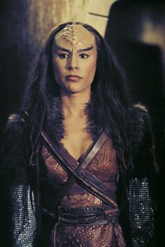 a woman with long black hair wearing armor