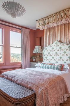 a bedroom with pink walls and curtains on the window sill, bed in foreground