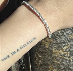 a person with a wrist tattoo that says one in a million on their left arm