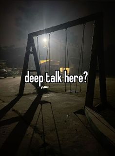 a swing set with the words deep talk here? on it in front of a dark background