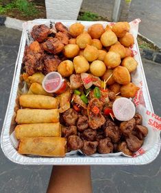 a tray filled with different types of food on top of a street side walk next to a sidewalk