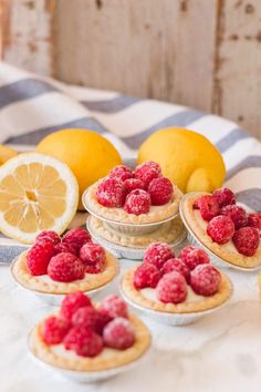 small tarts with raspberries and lemons on a table