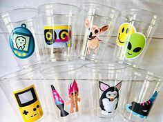 there are many plastic cups that have different pictures on them in the shape of animals