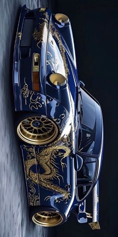 the top view of a blue sports car with gold dragon decals on it's side