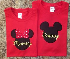 two red shirts with mickey and minnie mouse heads on them, one is for mom and the other is for dad