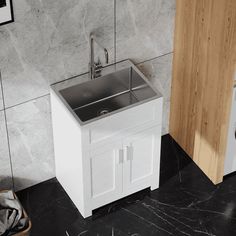 a white sink sitting next to a washer and dryer in a room with marble walls