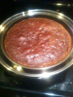 a round cake sitting on top of a metal pan in the oven, ready to be baked