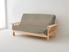 a wooden futon with a gray cover on it in front of a white wall