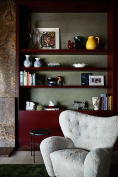 a white chair sitting in front of a book shelf