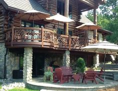 a large wooden house with patio furniture and umbrellas