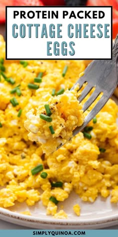 a fork full of scrambled eggs on a white plate with tomatoes and green onions in the background