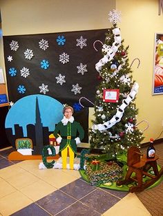 a decorated christmas tree in an office cubicle with decorations on the walls and around it