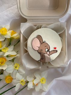 a small plate with a cartoon mouse on it next to some daffodils