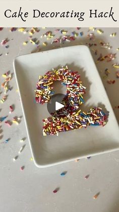 a cake decorated with sprinkles in the shape of a number on a plate