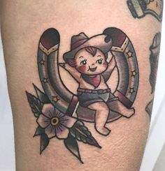 a small tattoo on the leg of a person with a hat and an arrow in it