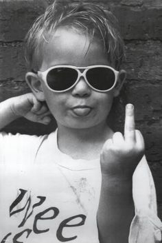 a young boy wearing sunglasses making the peace sign