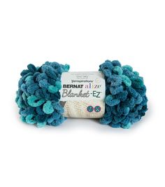 yarn ball with blue and green colors on the end, sitting in front of a white background