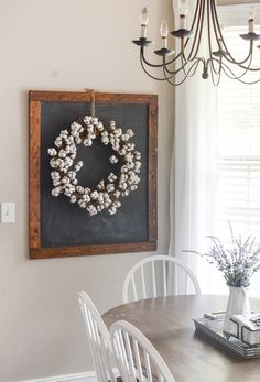 a dining room table with a wreath hanging on the wall