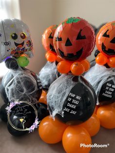 three halloween balloons sitting on top of each other in the shape of jack - o'- lanterns