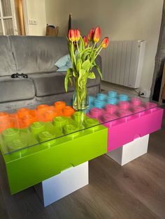 a vase with tulips in it sitting on a coffee table made out of legos