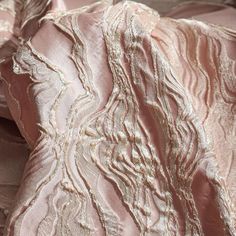 pink and gold fabric with wavy lines on the top, as if it were made from silk