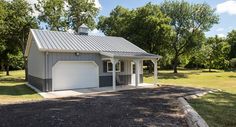 a garage in the middle of a field with lots of trees and grass around it