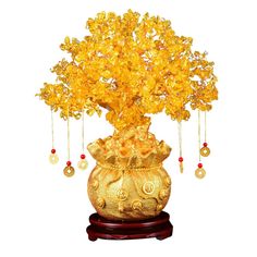 a golden vase filled with yellow flowers on top of a wooden stand