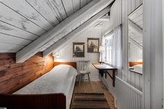 an attic bedroom with wood paneling and white walls