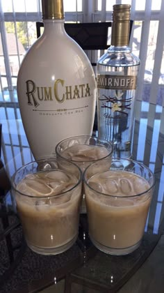 three glasses filled with ice cream next to a bottle of rumchata