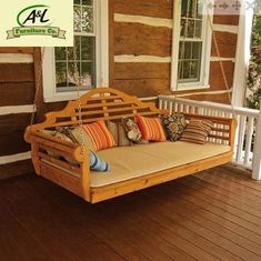 a wooden porch swing with pillows on it