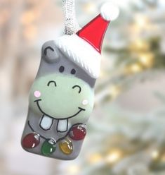 a glass ornament with a christmas hat on it's head hanging from a tree