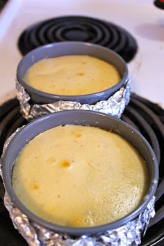 two pans filled with food sitting on top of an oven burner covered in tin foil